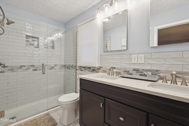 full bathroom with a sink, a stall shower, tile walls, and a textured ceiling
