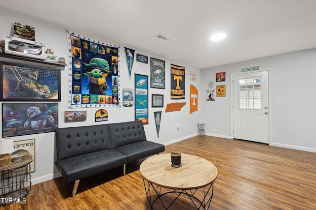 sitting room with baseboards, visible vents, and wood finished floors