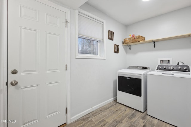 laundry room with light wood finished floors, baseboards, washer and dryer, and laundry area