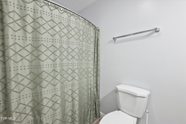 full bath with a shower with curtain and toilet