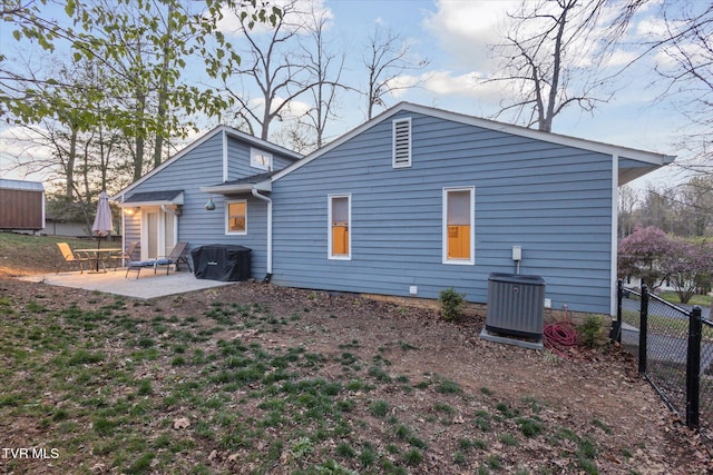 rear view of house featuring central air condition unit, fence, and a patio area