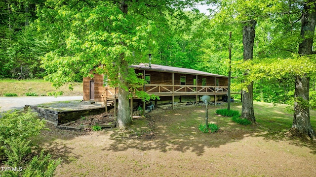 rear view of property featuring a deck and a wooded view