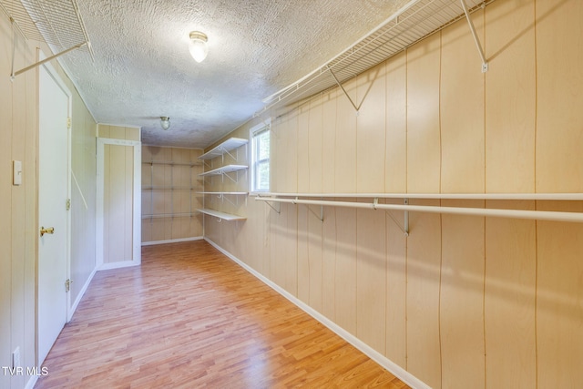 walk in closet with wood finished floors