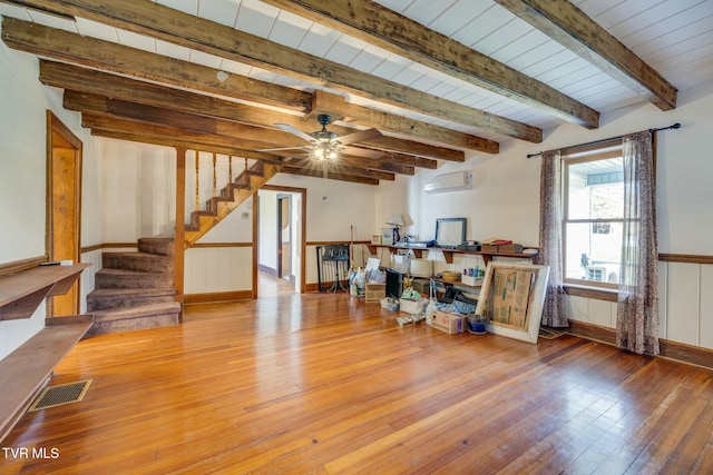interior space with stairway, a ceiling fan, wainscoting, visible vents, and hardwood / wood-style floors