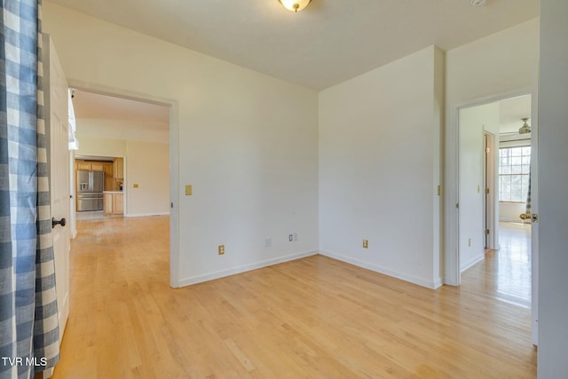 empty room featuring baseboards and light wood-style flooring