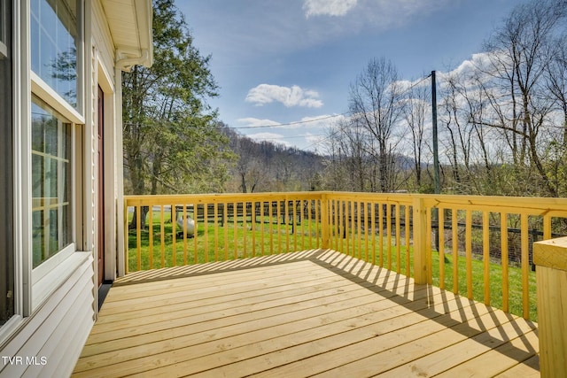 deck featuring a forest view and a yard