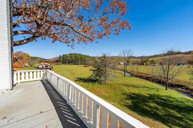 wooden terrace with a yard and a mountain view