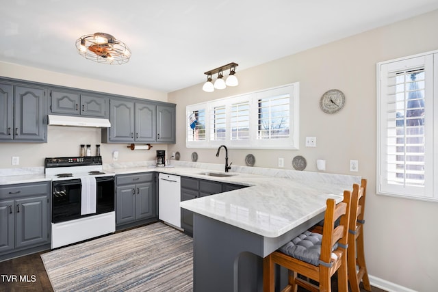 kitchen with range with electric cooktop, a sink, a peninsula, under cabinet range hood, and gray cabinets