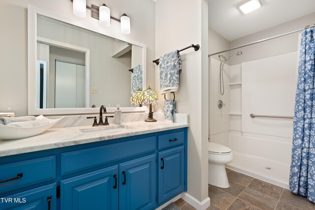 full bath with toilet, curtained shower, and vanity