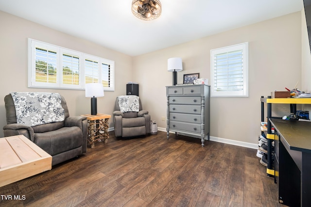 living area featuring baseboards and dark wood finished floors