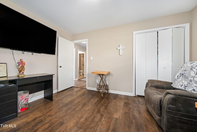 living area featuring baseboards and dark wood finished floors