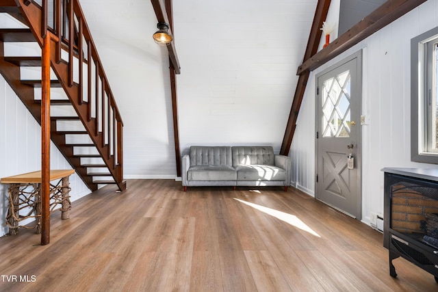 foyer with wood finished floors, vaulted ceiling with beams, and stairway
