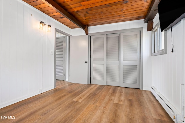 unfurnished bedroom with a closet, wooden ceiling, a baseboard heating unit, light wood finished floors, and beam ceiling