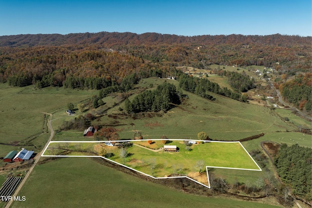 birds eye view of property featuring a wooded view and a rural view