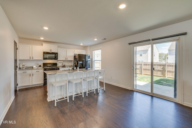 1205 Stamp Lodge Rd, Kingsport, TN 37660 - kitchen featuring dark wood-style flooring, an island with sink, white cabinets, light stone countertops, and black appliances