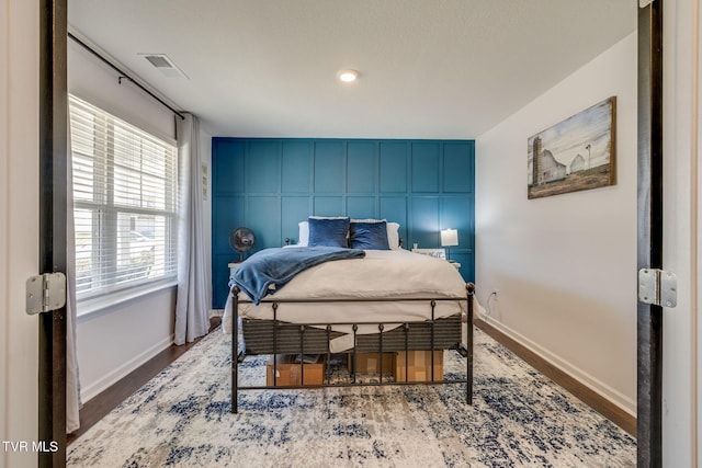 1205 Stamp Lodge Rd, Kingsport, TN 37660 - bedroom featuring wood finished floors, baseboards, an accent wall, and visible vents