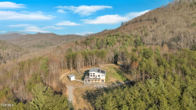 birds eye view of property featuring a wooded view and a mountain view