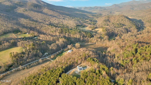 drone / aerial view featuring a mountain view and a view of trees