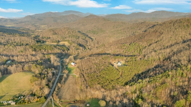 aerial view featuring a wooded view and a mountain view