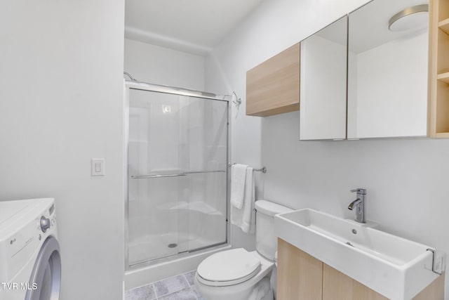 bathroom with a stall shower, toilet, vanity, and washer / dryer