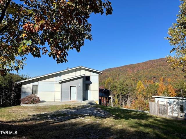 view of outbuilding featuring a wooded view and an outdoor structure