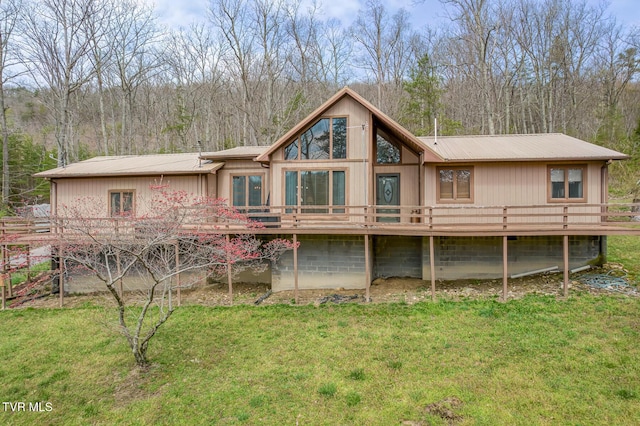 back of property with metal roof, a deck, and a yard