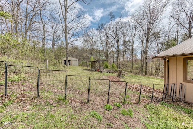 view of yard with an outbuilding, a gate, and fence