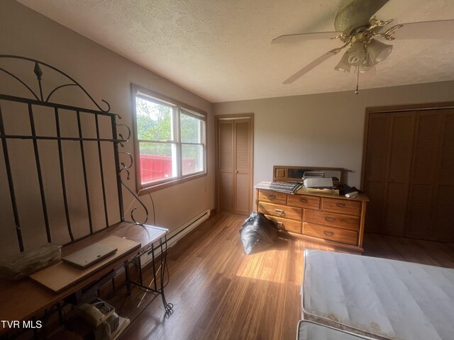 4235 Kiser Rd, Coeburn, VA 24230 - bedroom featuring wood finished floors, a textured ceiling, a ceiling fan, and two closets