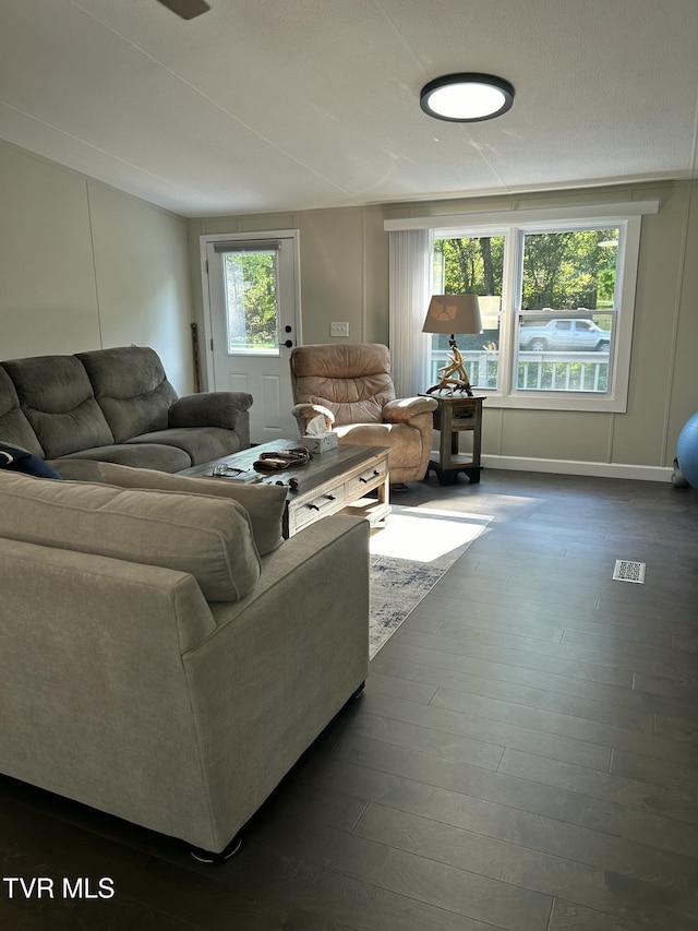living area featuring dark wood-type flooring and baseboards