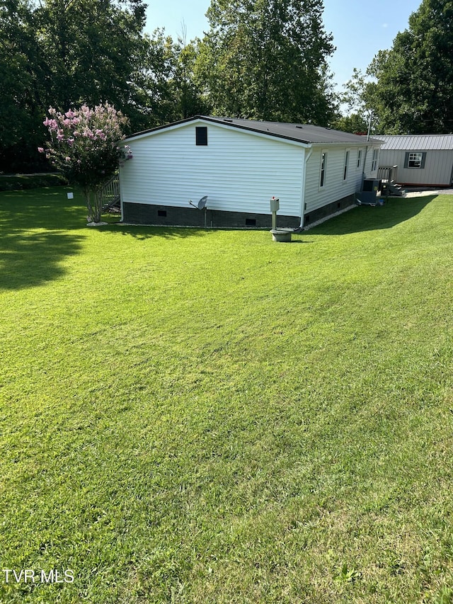exterior space with crawl space and a lawn