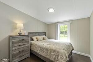 bedroom with baseboards and lofted ceiling