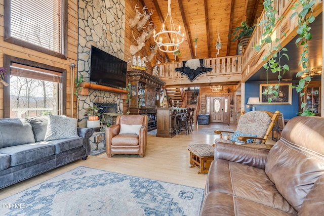 living area featuring a notable chandelier, wooden ceiling, a fireplace, wood finished floors, and beamed ceiling