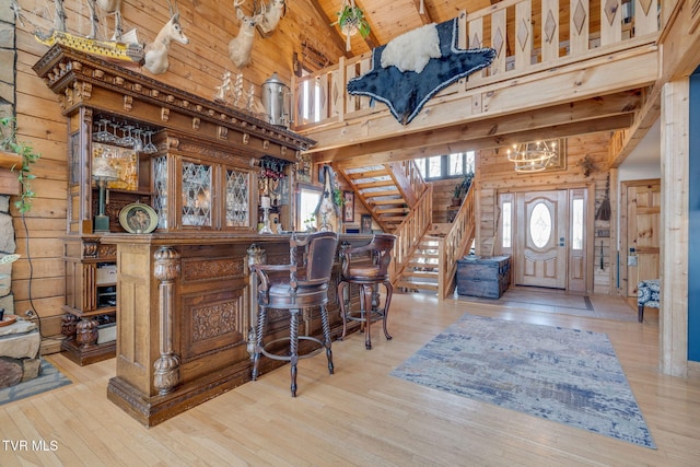bar with wood-type flooring, wood ceiling, wood walls, and beam ceiling