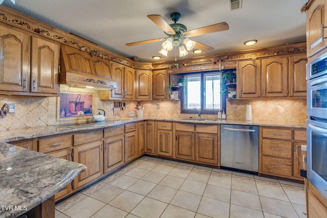 kitchen with visible vents, stainless steel appliances, brown cabinetry, and a ceiling fan