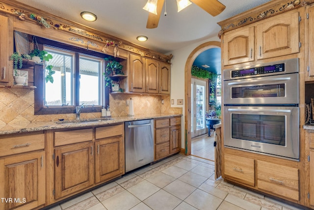 kitchen featuring a healthy amount of sunlight, a sink, appliances with stainless steel finishes, and open shelves