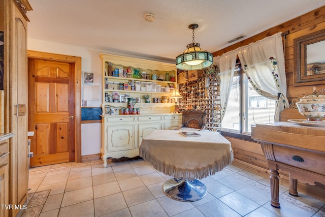 interior space featuring light tile patterned flooring, a textured ceiling, and visible vents
