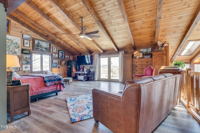 living area featuring a wealth of natural light, lofted ceiling with beams, wood finished floors, and wood ceiling