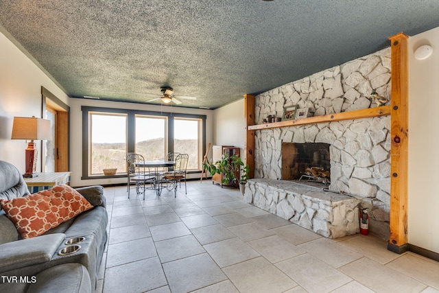 living room with a textured ceiling, a ceiling fan, and a stone fireplace