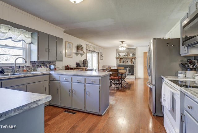216 Nelson Ave, Piney Flats, TN 37686 - kitchen featuring stainless steel microwave, white range with electric stovetop, a sink, and gray cabinetry
