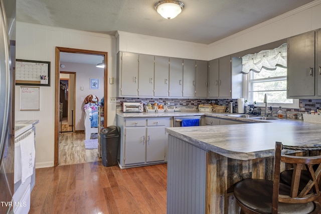 216 Nelson Ave, Piney Flats, TN 37686 - kitchen featuring tasteful backsplash, crown molding, gray cabinetry, a sink, and wood finished floors