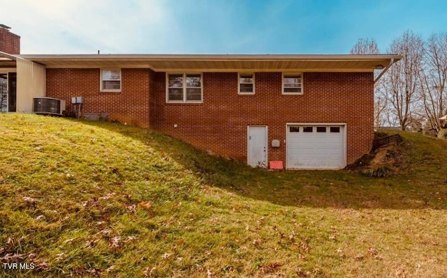 216 Nelson Ave, Piney Flats, TN 37686 - back of property featuring an attached garage, brick siding, central AC unit, and a yard