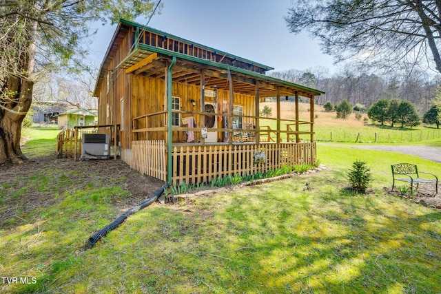 view of side of property with an outdoor structure, a pole building, central AC unit, and a lawn
