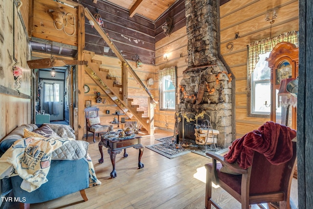living room with wooden ceiling, stairway, wood finished floors, wood walls, and a healthy amount of sunlight