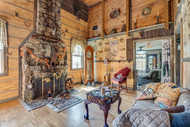 living room featuring a high ceiling, wood finished floors, wooden walls, and a wealth of natural light