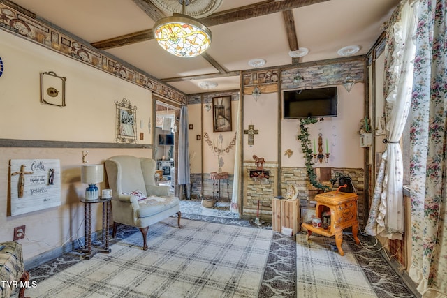 living area with coffered ceiling, beamed ceiling, and wainscoting