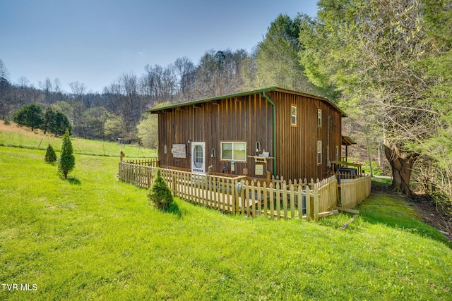 view of outbuilding with a forest view and fence