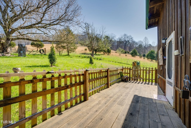 wooden terrace featuring a rural view and a lawn