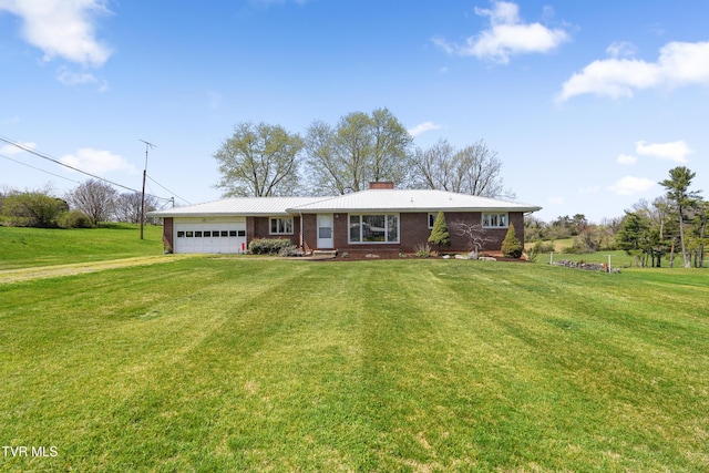 single story home with a chimney, driveway, a front lawn, an attached garage, and brick siding