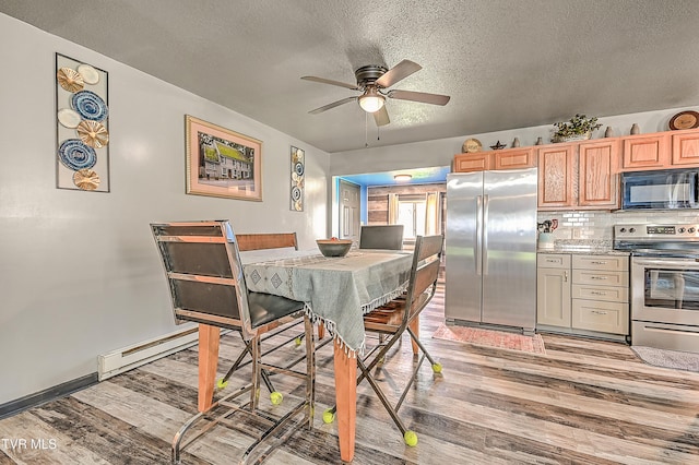 dining space with a textured ceiling, light wood-type flooring, baseboard heating, and a ceiling fan