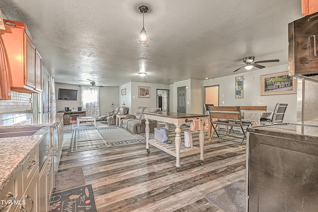 kitchen with open floor plan, a ceiling fan, and wood finished floors
